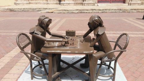 Statue en métal de deux personnes jouant aux échecs