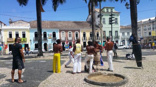 Groupe d'hommes faisant de la capoeira sur une place